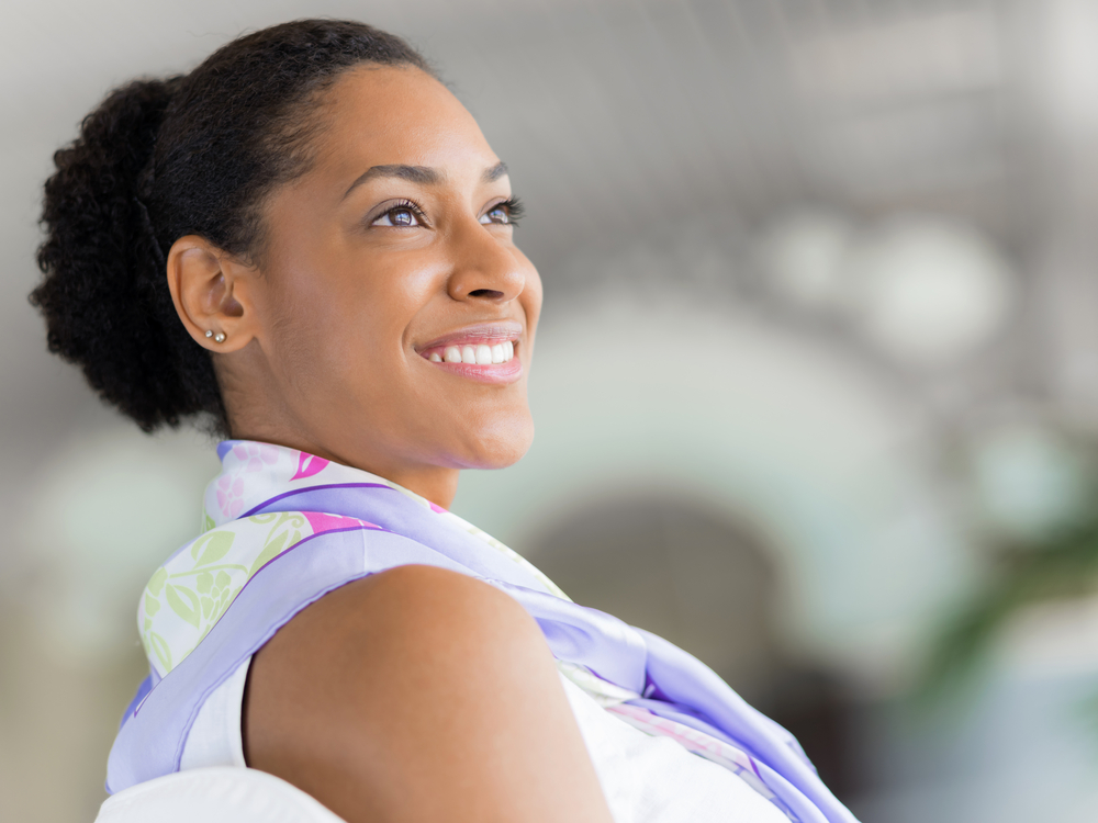 A lady with natural curls styled with hair gel helps someone in her office on a daily basis.