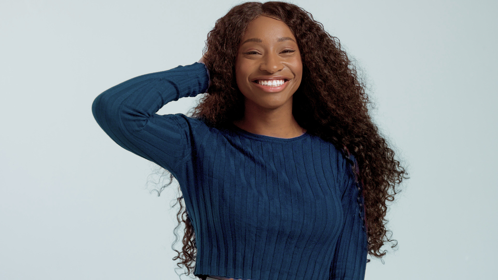 A with mid-back length curly hair with a nice blue causal shirt. 