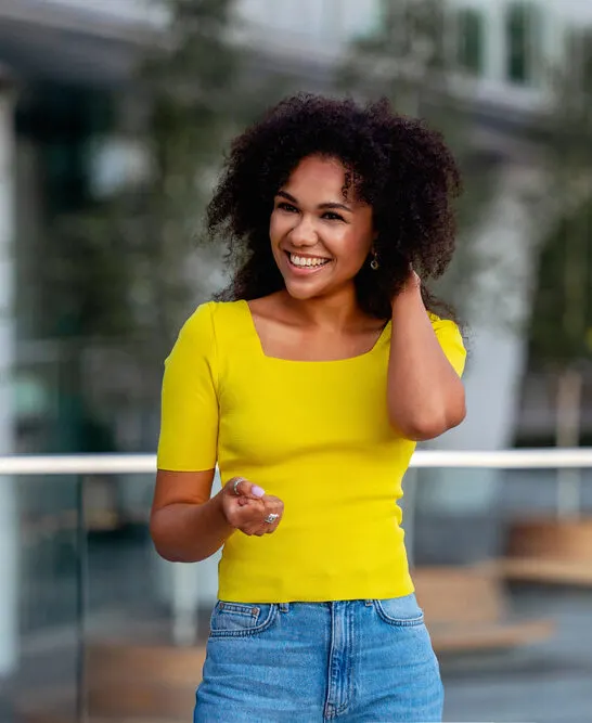 A cute black girl with beachy waves styled with dry texture spray on damp hair to create natural volume and soft texture.