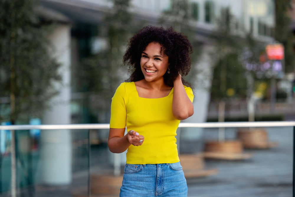 A cute black girl with beachy waves styled with dry texture spray on damp hair to create natural volume and soft texture.