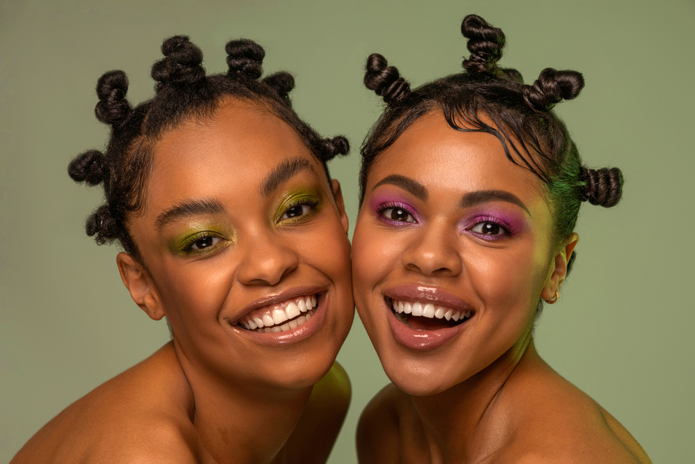 Two beautiful African women with wavy hair wearing Bantu knots overnight after washing their hair with a sulfate-free shampoo.
