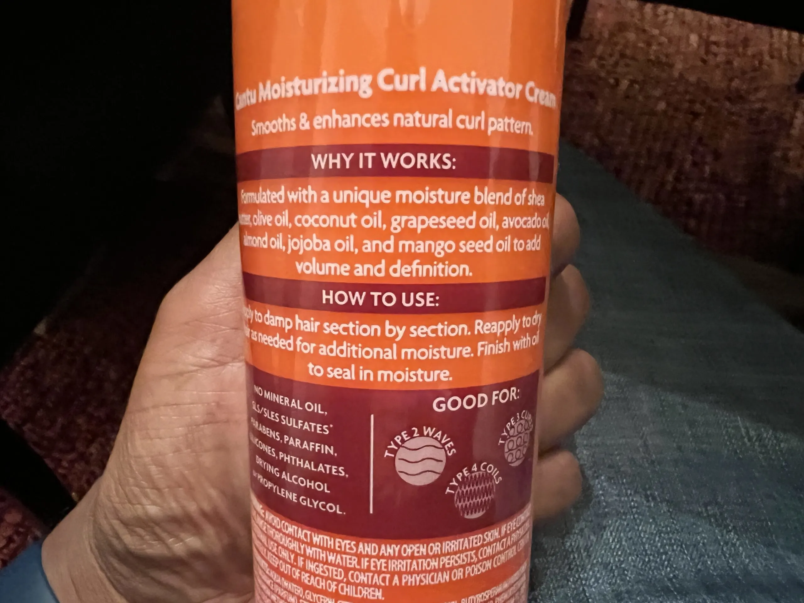 Applying Cantu Shea Moisturizing Curl Activator Cream to hair, showing its effectiveness in curl enhancement and shine.