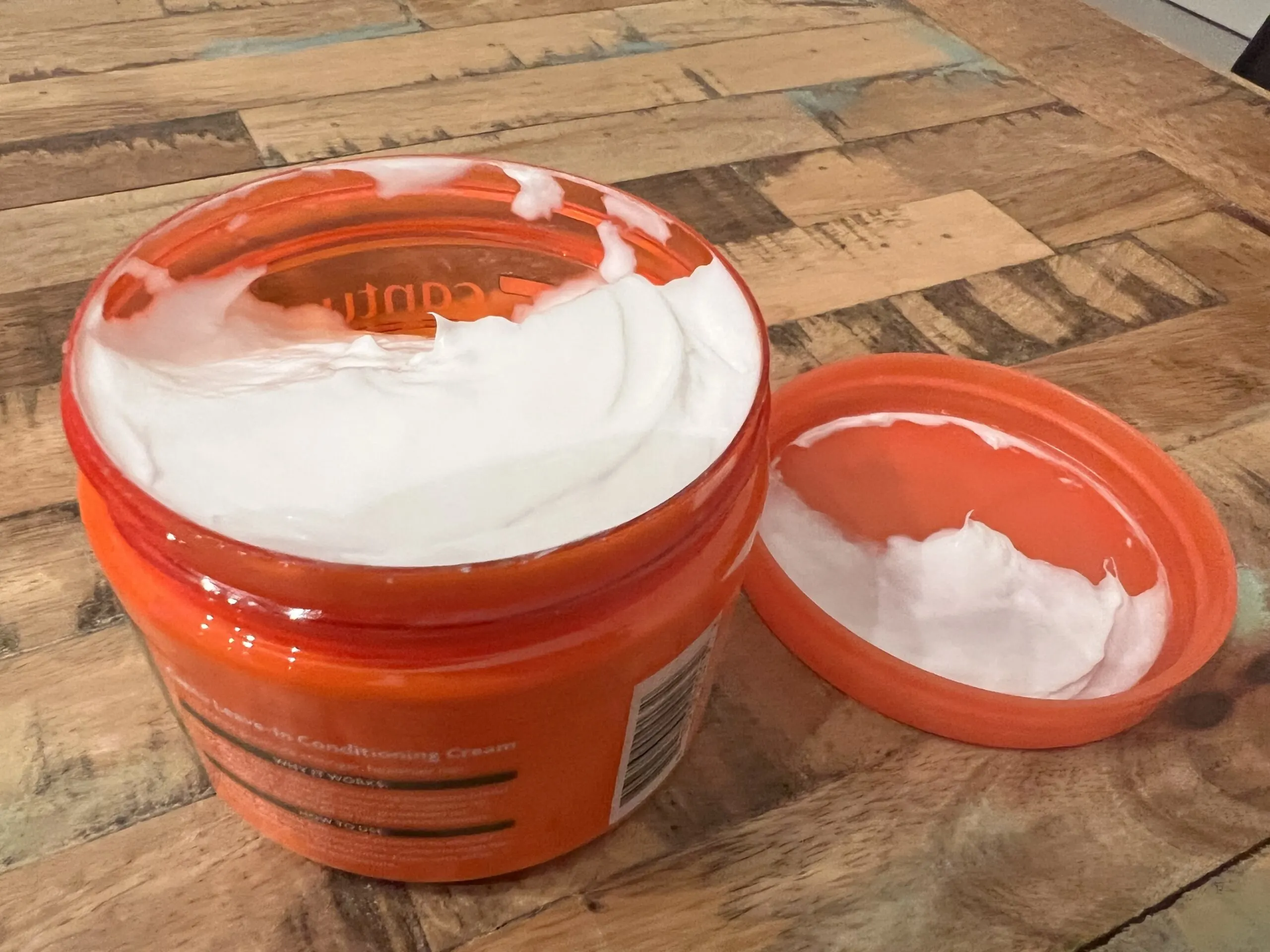 Close-up view of Cantu Shea Butter Leave-In Conditioning Cream's texture, emphasizing its moisturizing and repairing properties for hair.