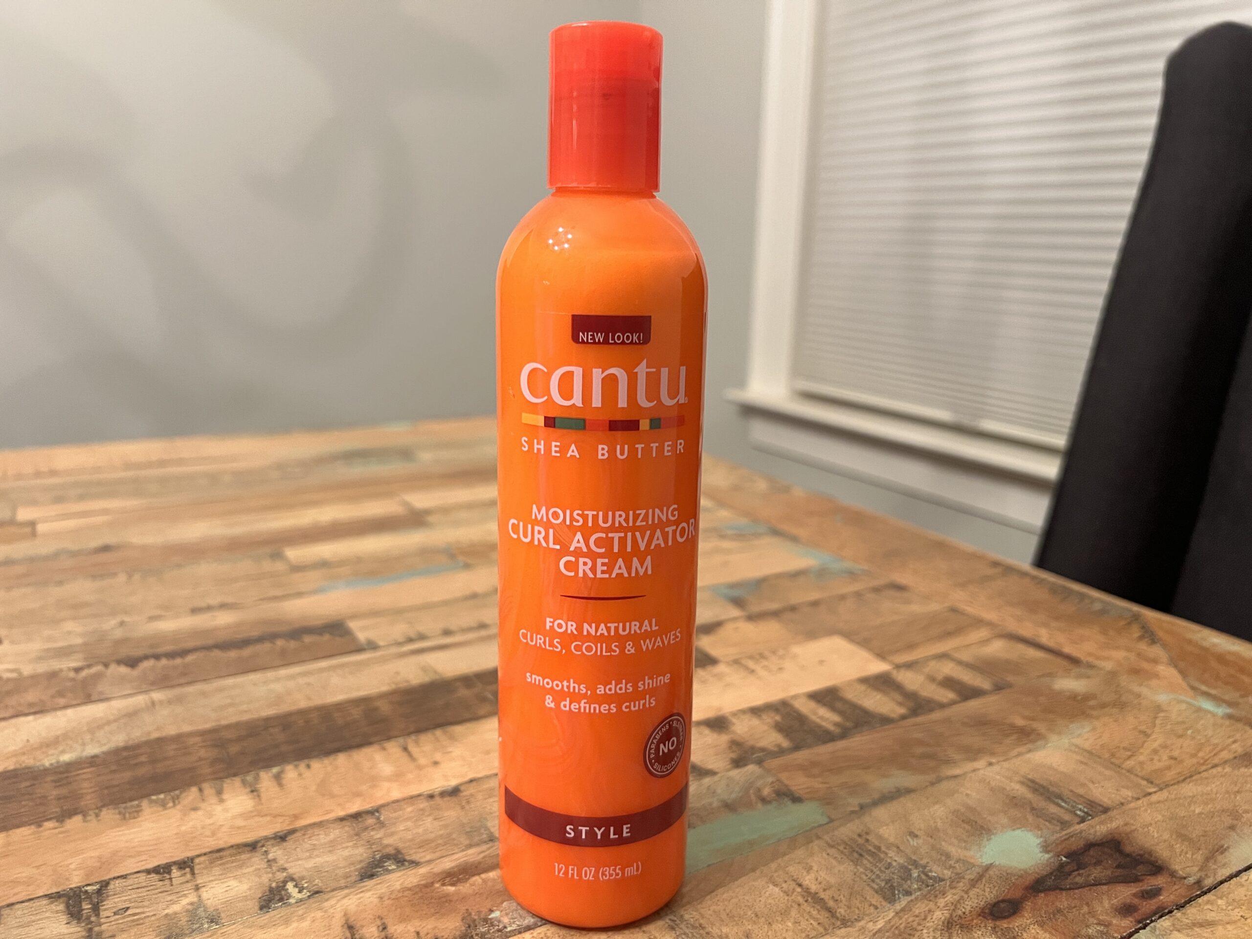 Bottle of Cantu Shea Moisturizing Curl Activator Cream, designed to enhance curl definition and add shine.