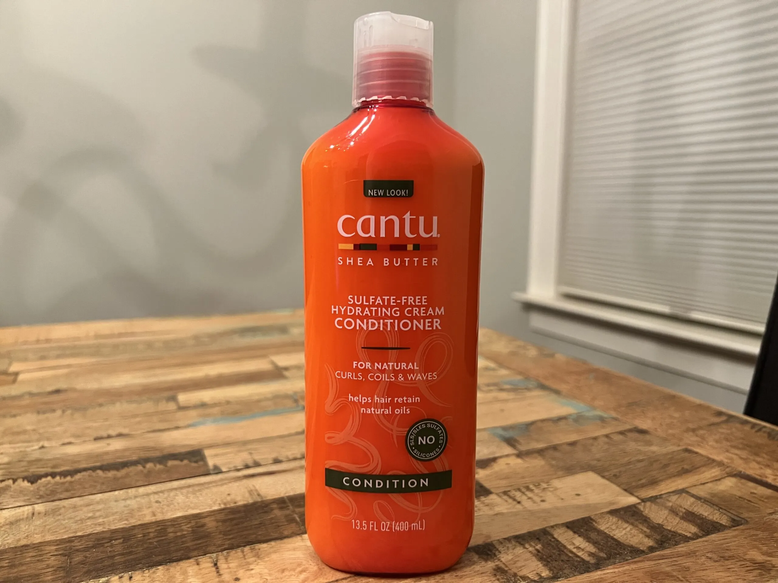 Cantu Shea Butter Sulfate-Free Hydrating Cream Conditioner bottle, ideal for moisturizing natural hair and retaining oils.