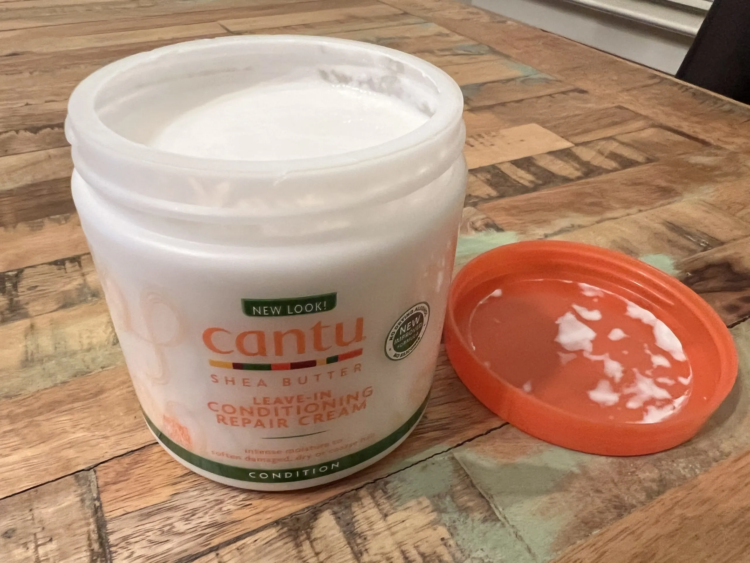 Close-up view of the rich, creamy texture of Cantu Leave-In Conditioning Repair Cream, highlighting its moisturizing properties for hair care.