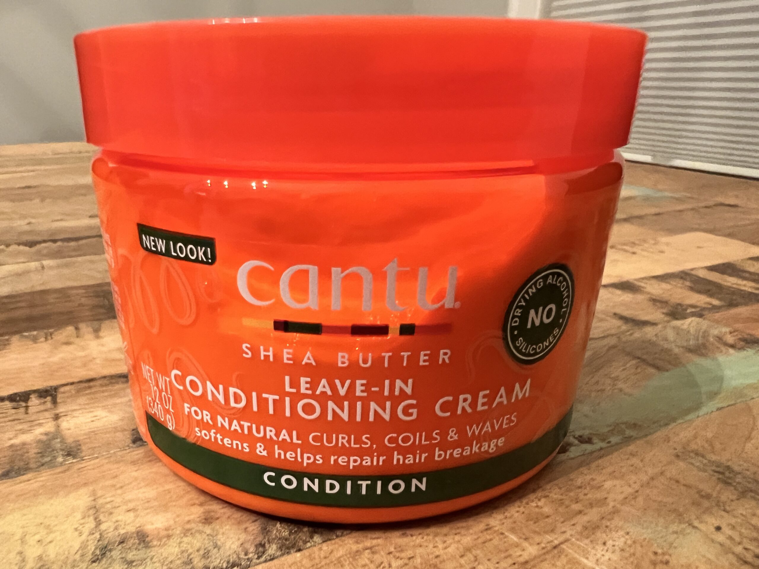 Cantu Shea Butter Leave-In Conditioning Cream bottle, designed to soften and reduce hair breakage.