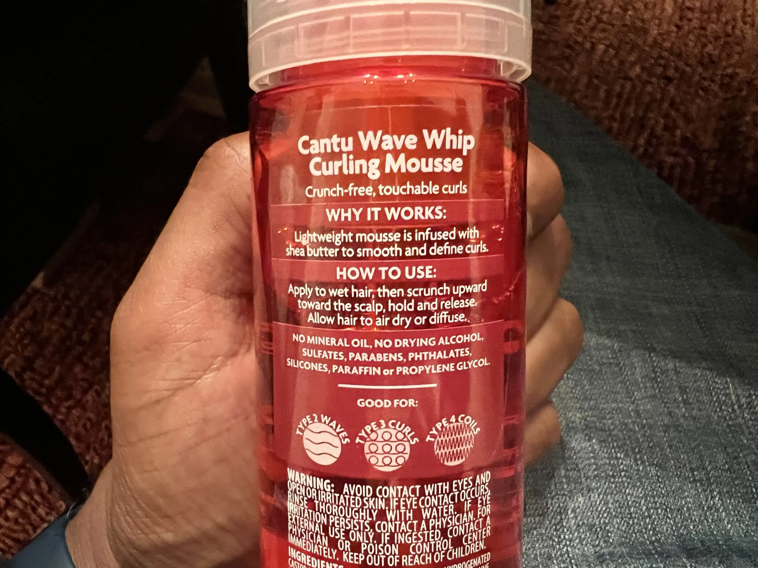 Application of Cantu Shea Butter Wave Whip Curling Mousse, showcasing its lightweight formula for curl definition.