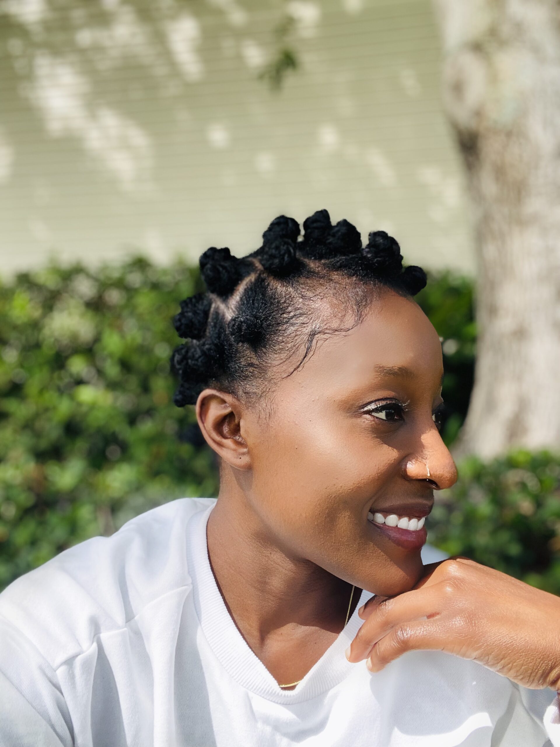 A cute black girl wearing a classic two-strand twist Bantu knot hairstyle