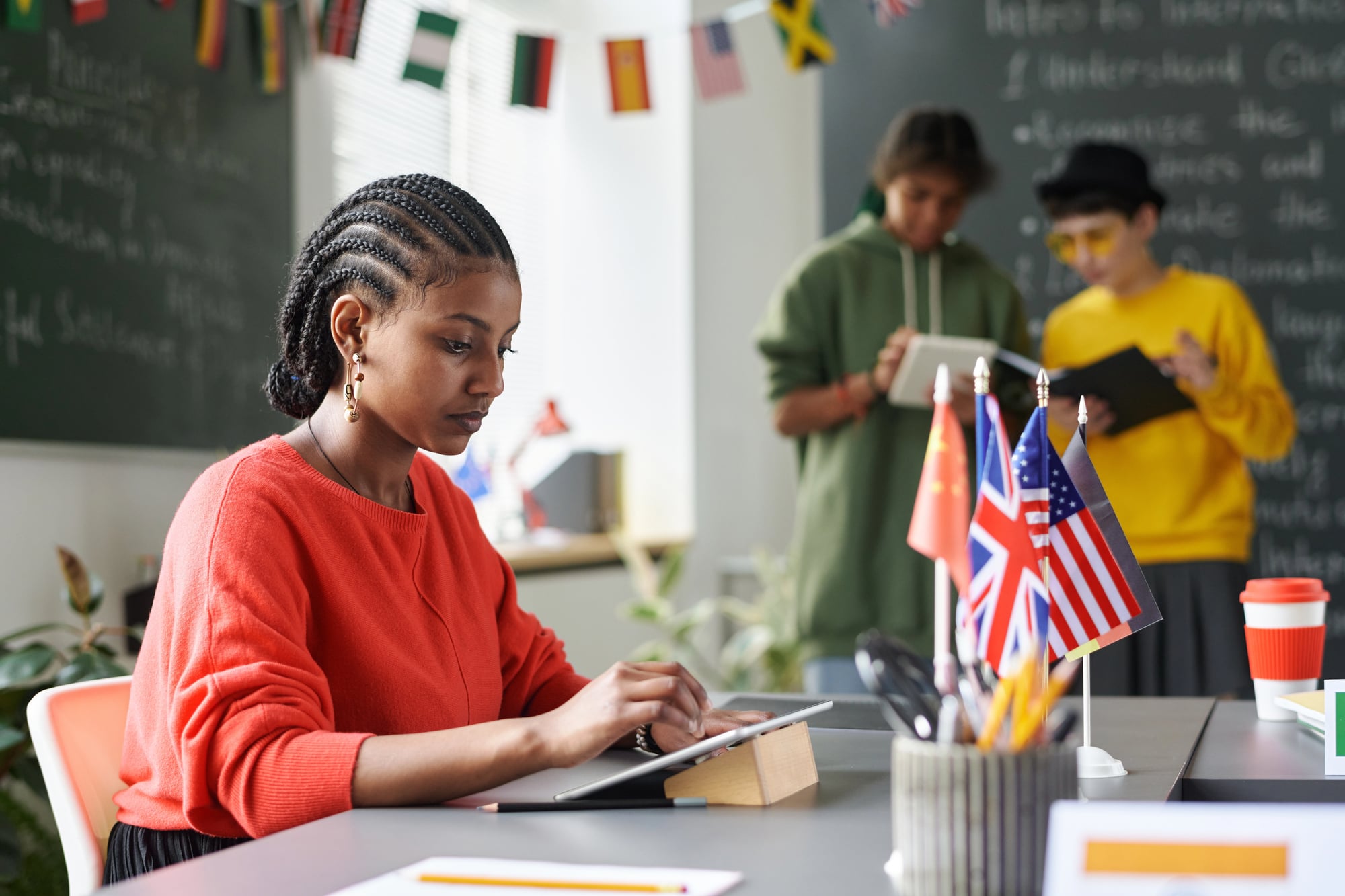 Side view of a Black woman's cornrows as she works at a tablet