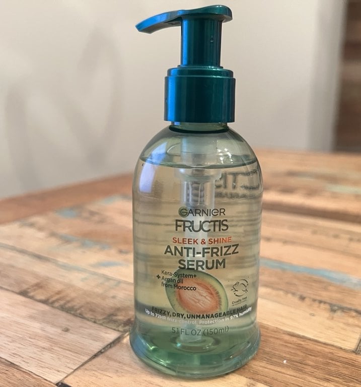 Pump bottle of Garnier Fructis Sleek and Shine Anti-Frizz Serum on a wood table