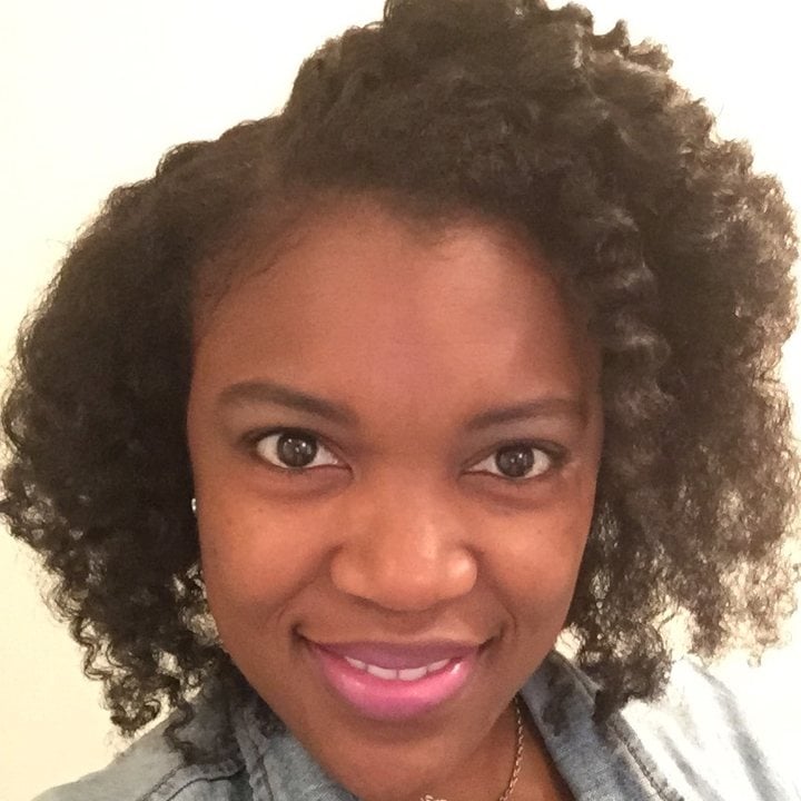 Kira Byrd, co-founder of Curl Centric, smiling, with her natural curly hair worn loose